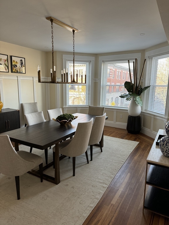 3 Alton Place, Unit 2 Brookline, MA 02446 - Photo 12 of 42 a view of a dining room and livingroom with furniture wooden floor a rug a potted plant and a chandelier