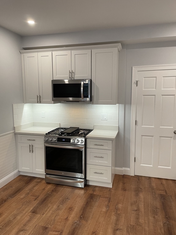 3 Alton Place, Unit 2 Brookline, MA 02446 - Photo 15 of 42 a kitchen with granite countertop white cabinets and stainless steel appliances