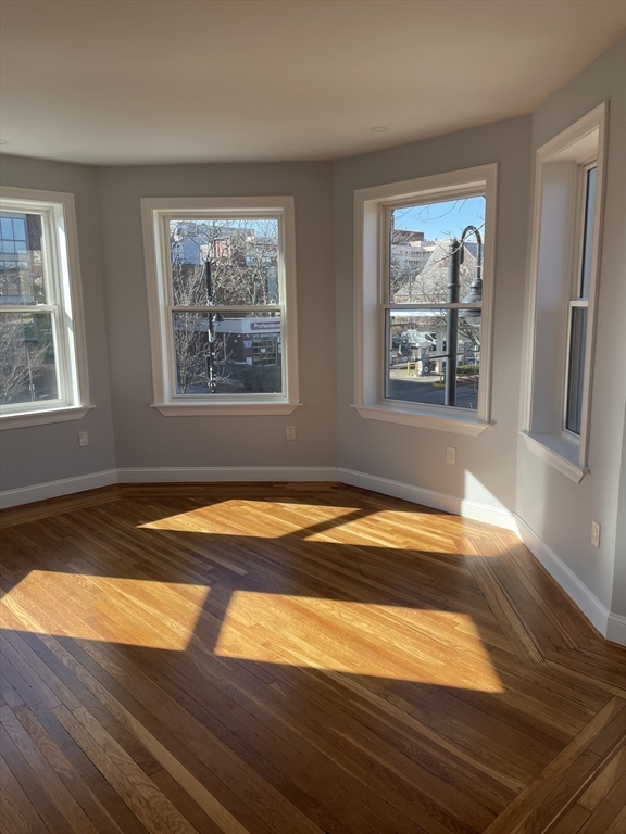 3 Alton Place, Unit 2 Brookline, MA 02446 - Photo 2 of 42 a view of empty room with window and wooden floor