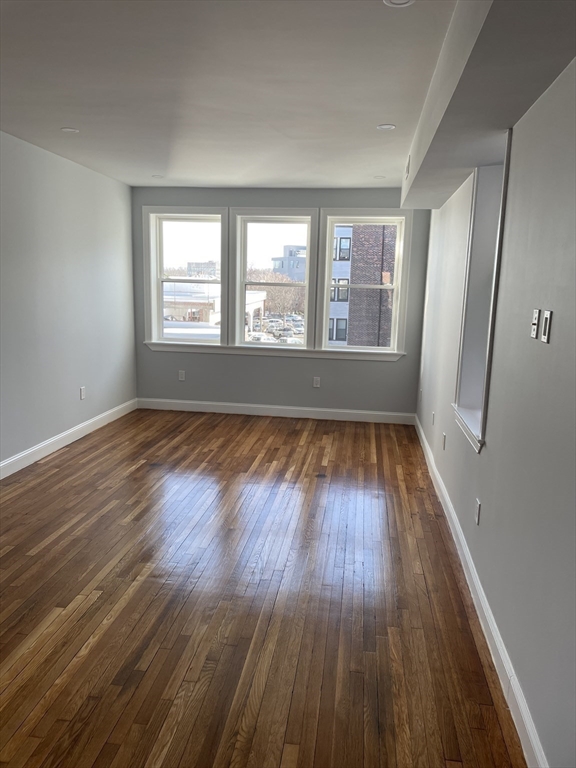 3 Alton Place, Unit 2 Brookline, MA 02446 - Photo 21 of 42 a view of an empty room with wooden floor and a window