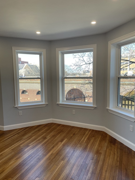 3 Alton Place, Unit 2 Brookline, MA 02446 - Photo 26 of 42 a view of an empty room with wooden floor and a window