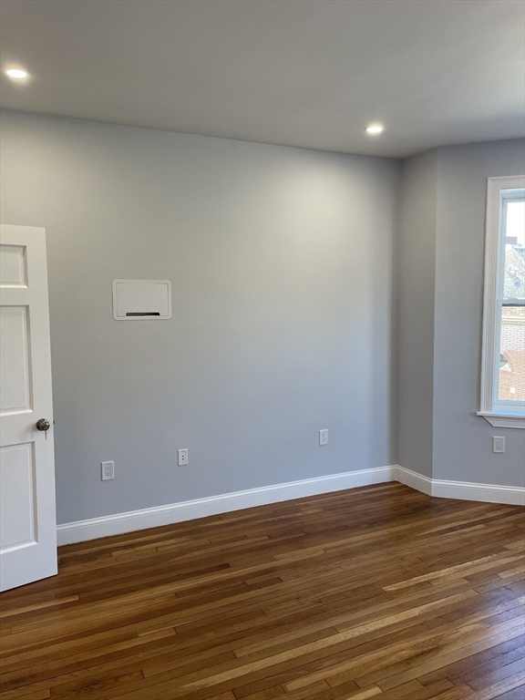 3 Alton Place, Unit 2 Brookline, MA 02446 - Photo 28 of 42 a view of an empty room with wooden floor and a window