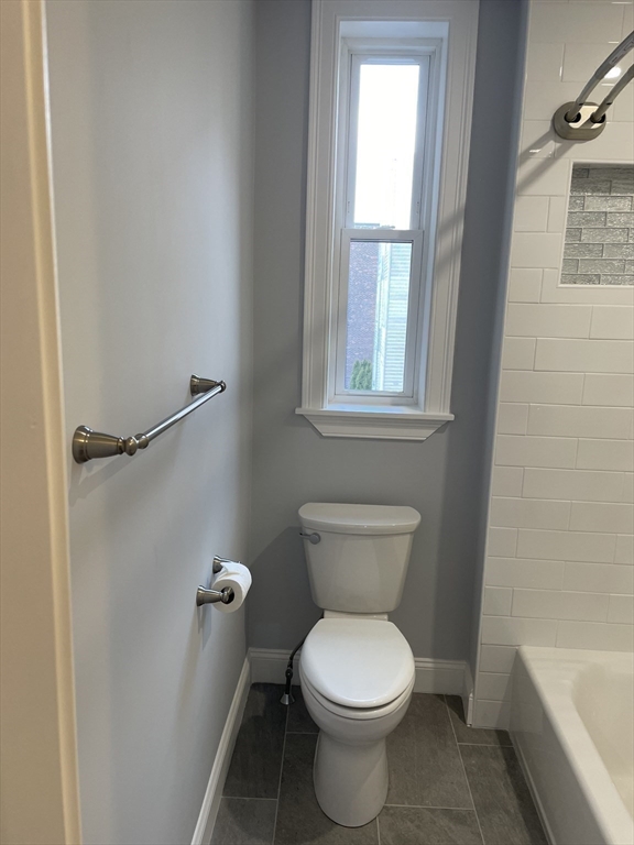 3 Alton Place, Unit 2 Brookline, MA 02446 - Photo 32 of 42 a white toilet sitting in a bathroom next to a window
