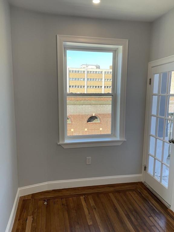3 Alton Place, Unit 2 Brookline, MA 02446 - Photo 8 of 42 an empty room with wooden floor and a window