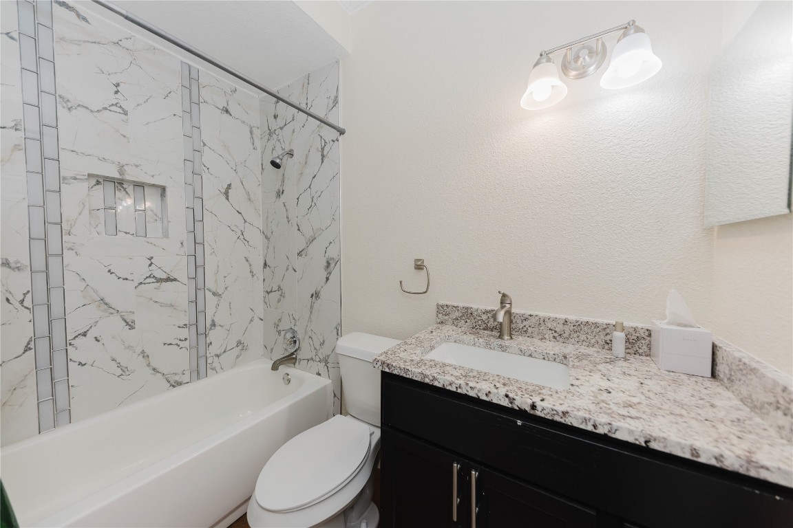 107 Silver Fox Waco, TX 76705 - Photo 27 of 33 a bathroom with a granite countertop bathtub sink vanity mirror and toilet