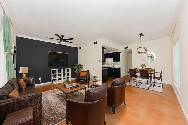 a living room with furniture a flat screen tv and kitchen view