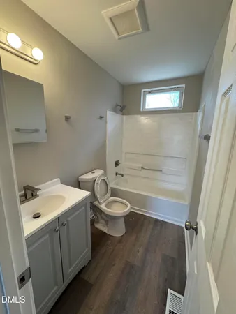 a bathroom with a granite countertop toilet a sink and a mirror