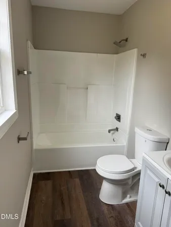 a white toilet sitting next to a bath tub