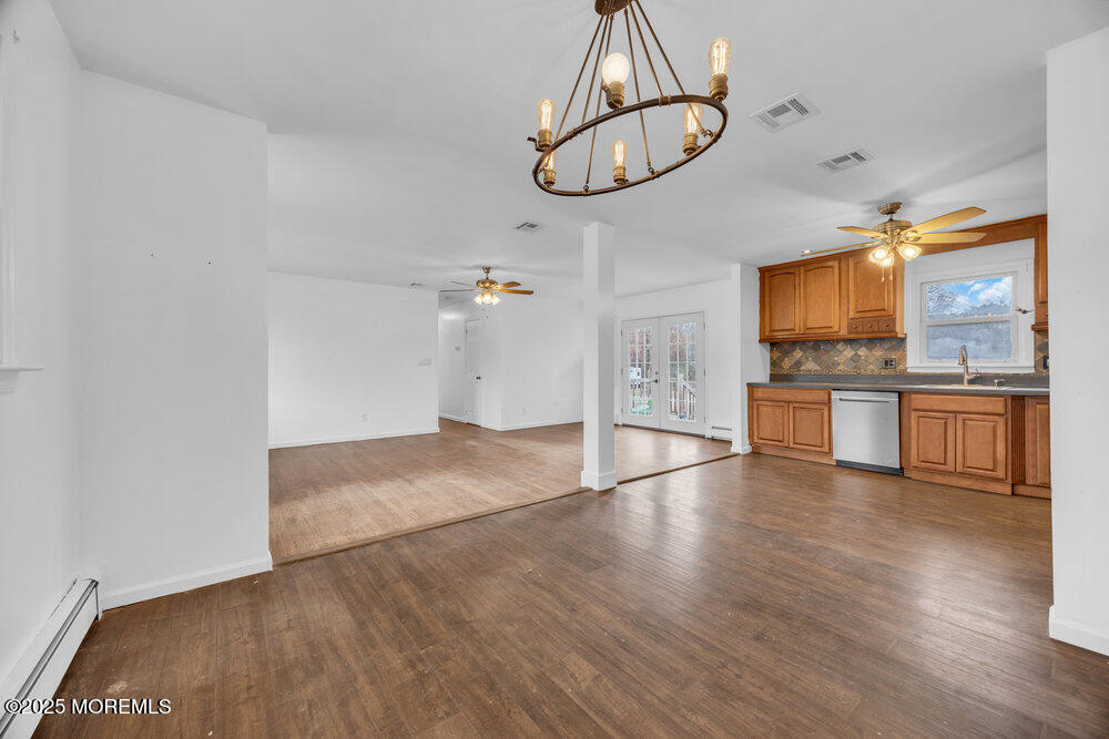 Undisclosed Address New Egypt, NJ 08533 - Photo 8 of 28 an empty room with wooden floor stainless steel appliances and chandelier