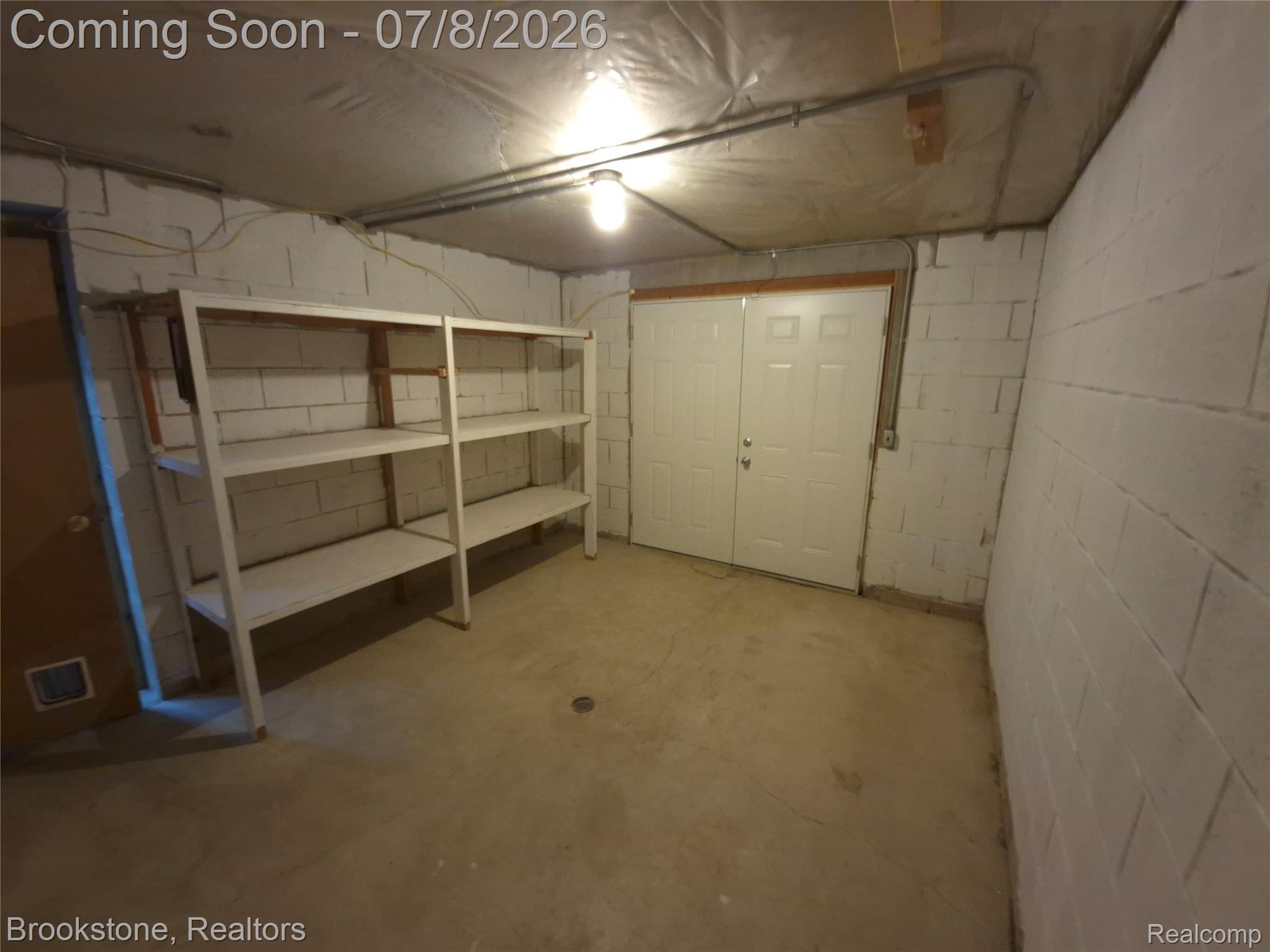 4140 South Henderson Road Davison, MI 48423 - Photo 82 of 98 Basement area featuring painted concrete block walls, concrete flooring, and a double-door entry