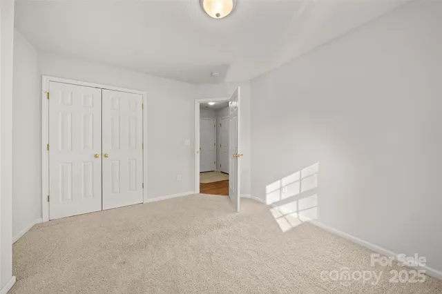 a view of an empty room with window and hardwood floor