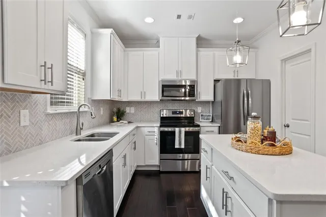 a kitchen with cabinets appliances a sink and a window