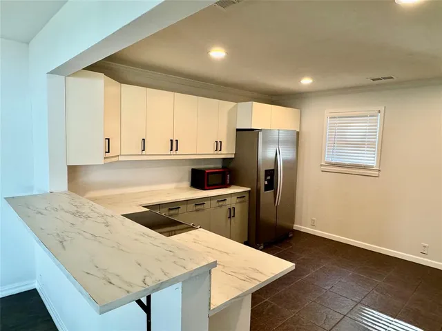 a kitchen with a refrigerator a sink and cabinets