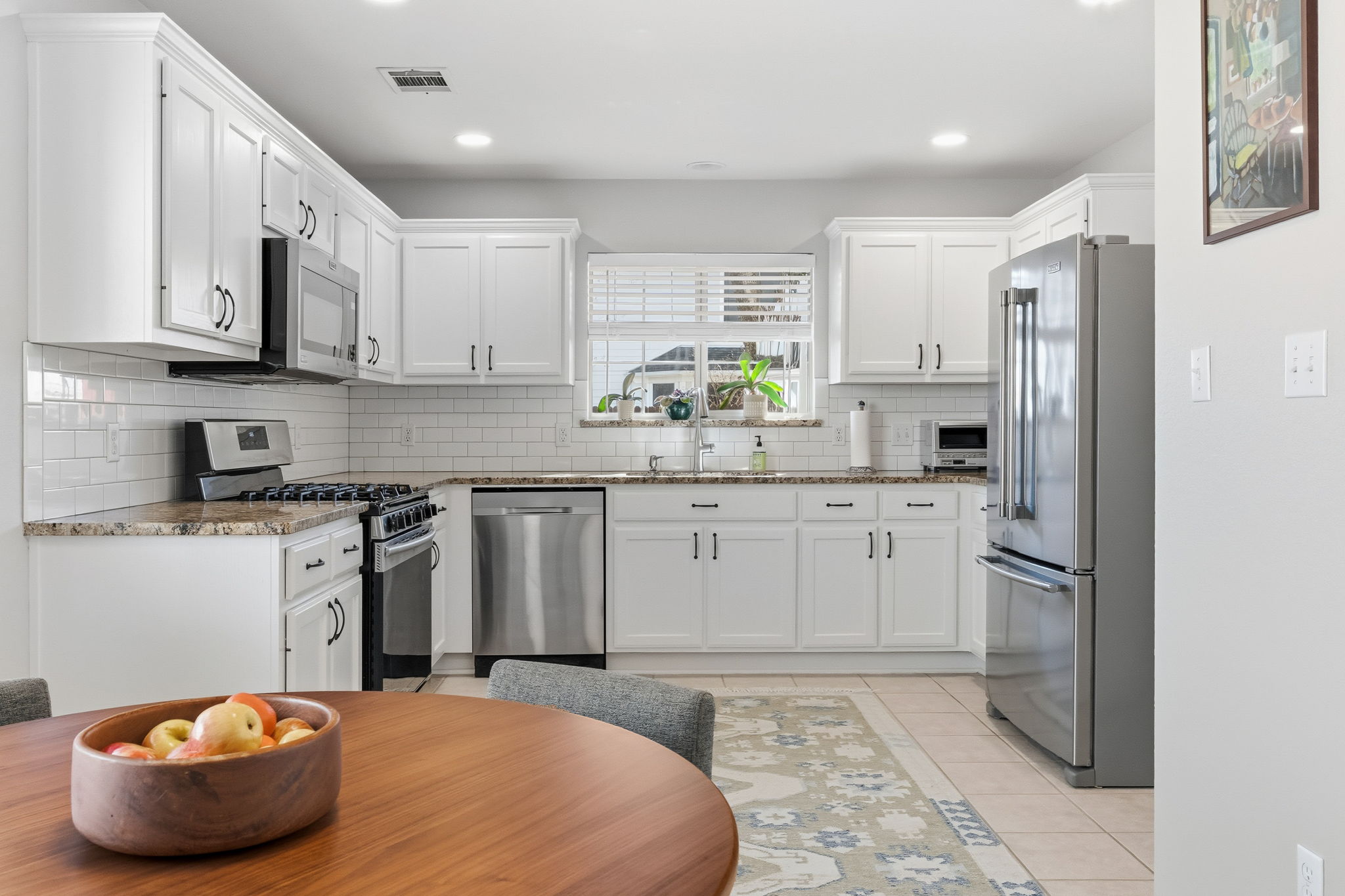 a kitchen with stainless steel appliances a refrigerator sink and cabinets