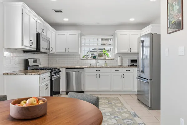 a kitchen with stainless steel appliances a refrigerator sink and cabinets