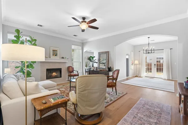 a living room with furniture a fireplace and a chandelier