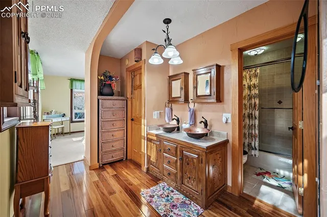 a kitchen with stainless steel appliances granite countertop a refrigerator a stove and a sink with wooden floor