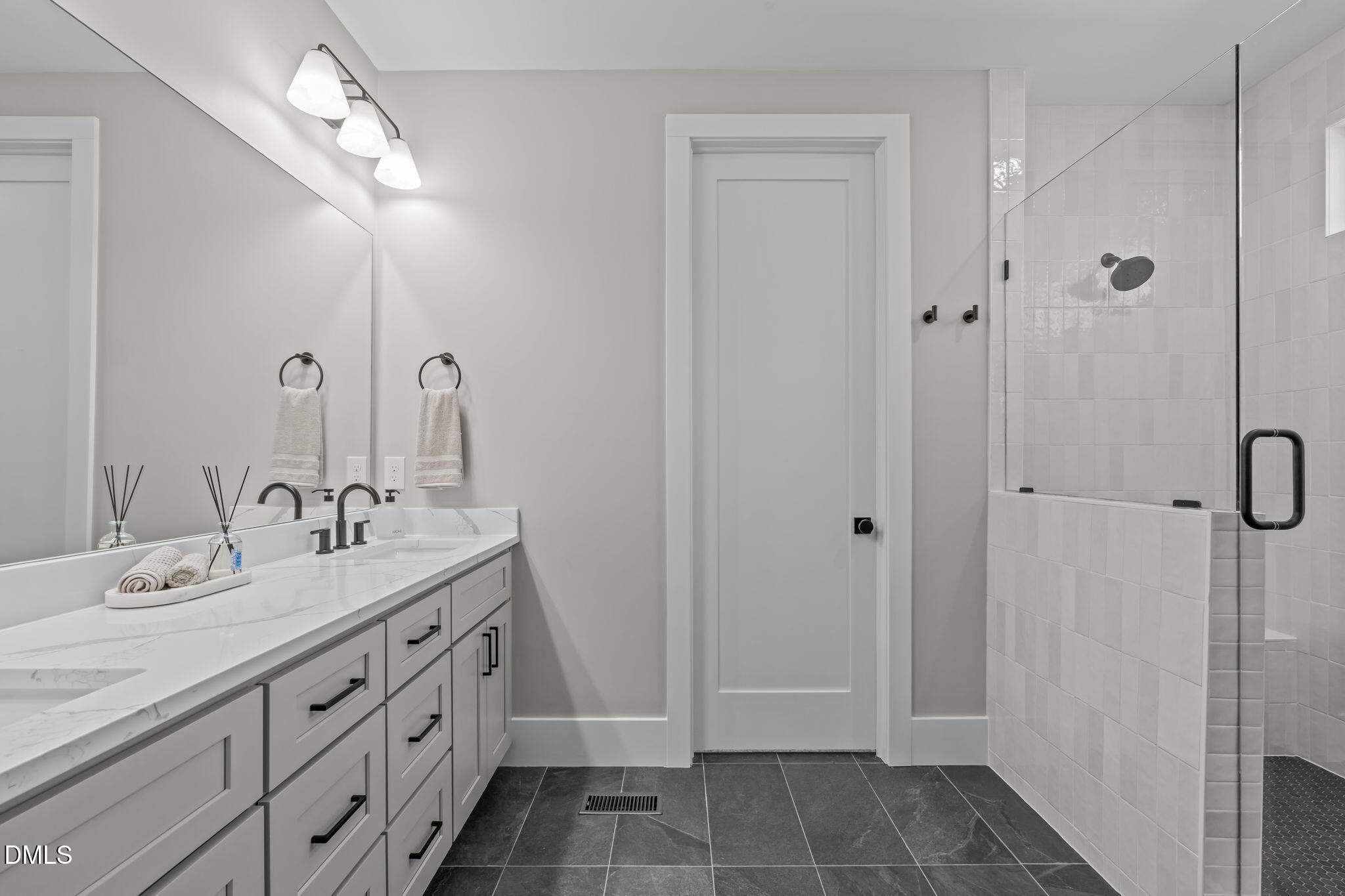 637 Conover Road, Unit A Durham, NC 27703 - Photo 26 of 51 a spacious bathroom with a double vanity sink a large mirror and shower