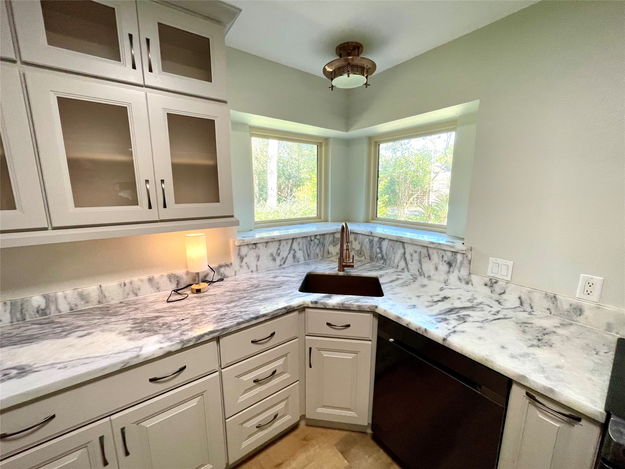 216 Woerner Road Houston, TX 77090 - Photo 13 of 33 a kitchen with granite countertop a sink stainless steel appliances white cabinets and a window