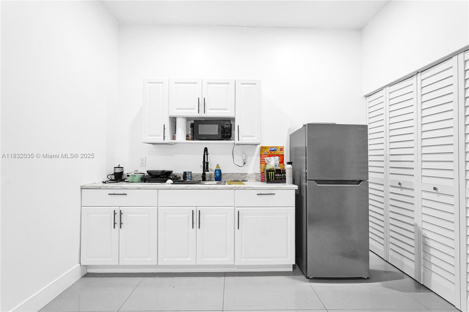 12735 Southwest 211th Street, Unit 12735 Miami, FL 33177 - Photo 19 of 45 a kitchen with white cabinets and refrigerator
