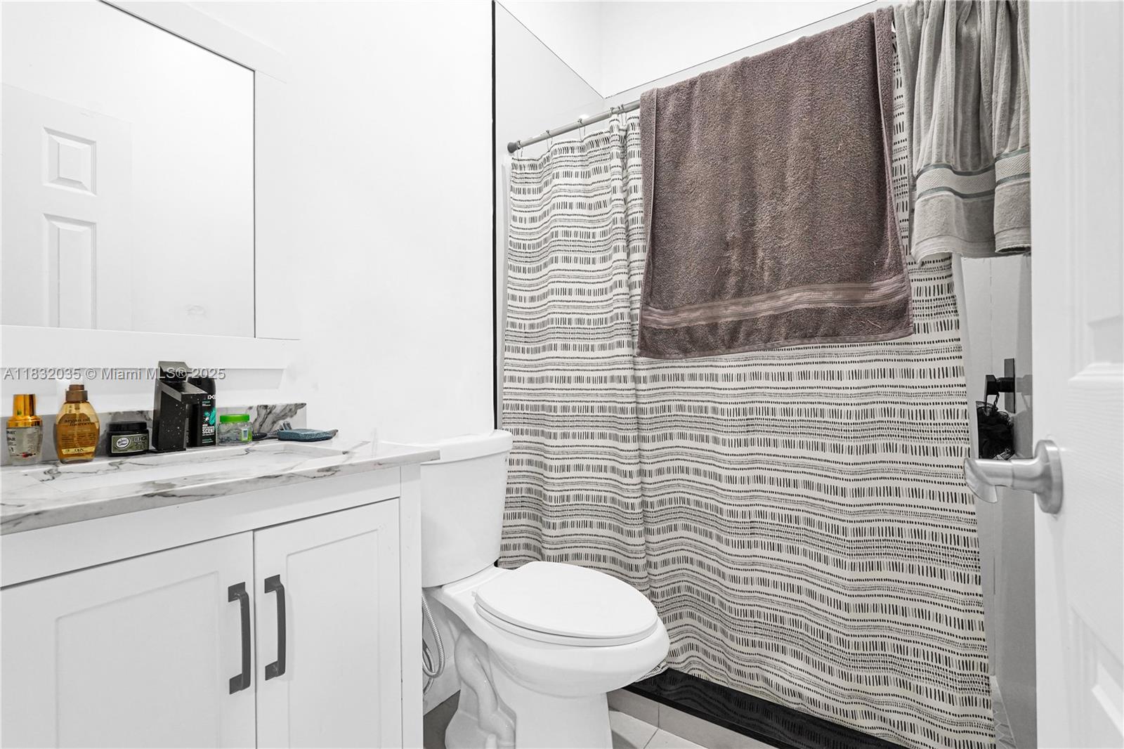12735 Southwest 211th Street, Unit 12735 Miami, FL 33177 - Photo 20 of 45 a bathroom with a granite countertop toilet sink and mirror
