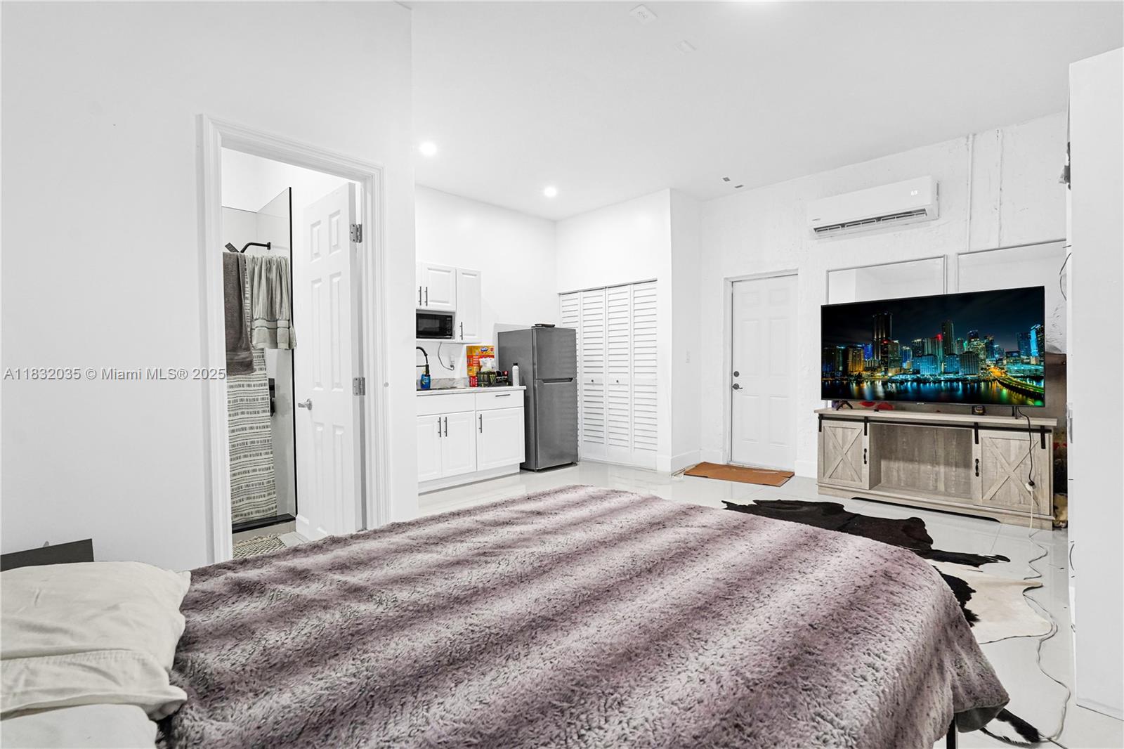 12735 Southwest 211th Street, Unit 12735 Miami, FL 33177 - Photo 21 of 45 a bedroom with a bed and a flat screen tv