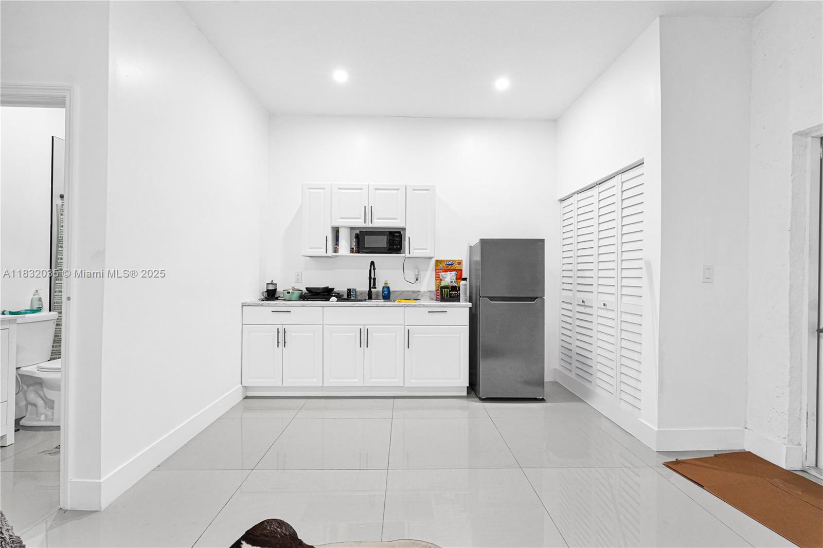 12735 Southwest 211th Street, Unit 12735 Miami, FL 33177 - Photo 22 of 45 a kitchen with a refrigerator and white cabinets