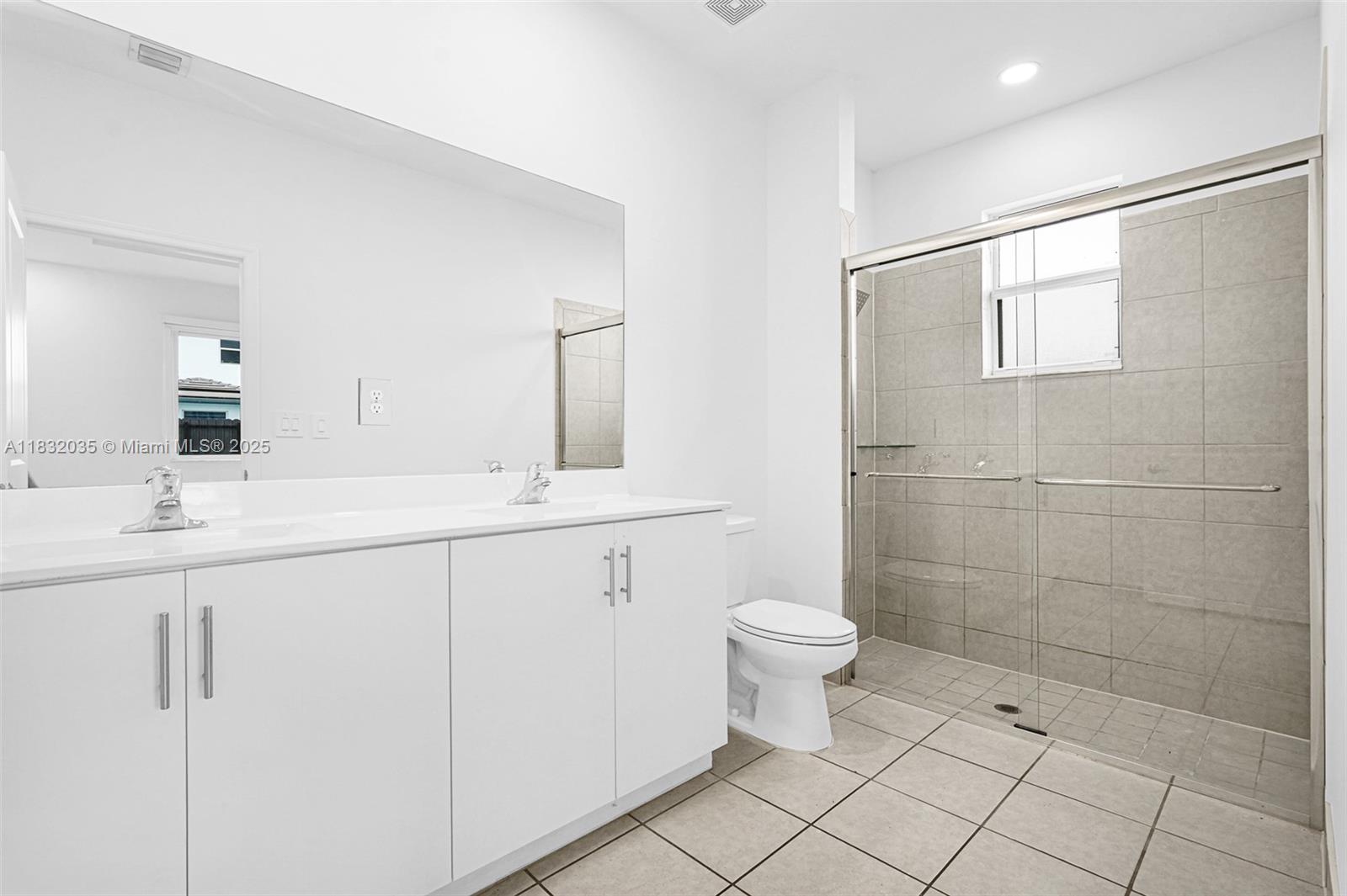 12735 Southwest 211th Street, Unit 12735 Miami, FL 33177 - Photo 30 of 45 a bathroom with a double vanity sink a toilet and a mirror