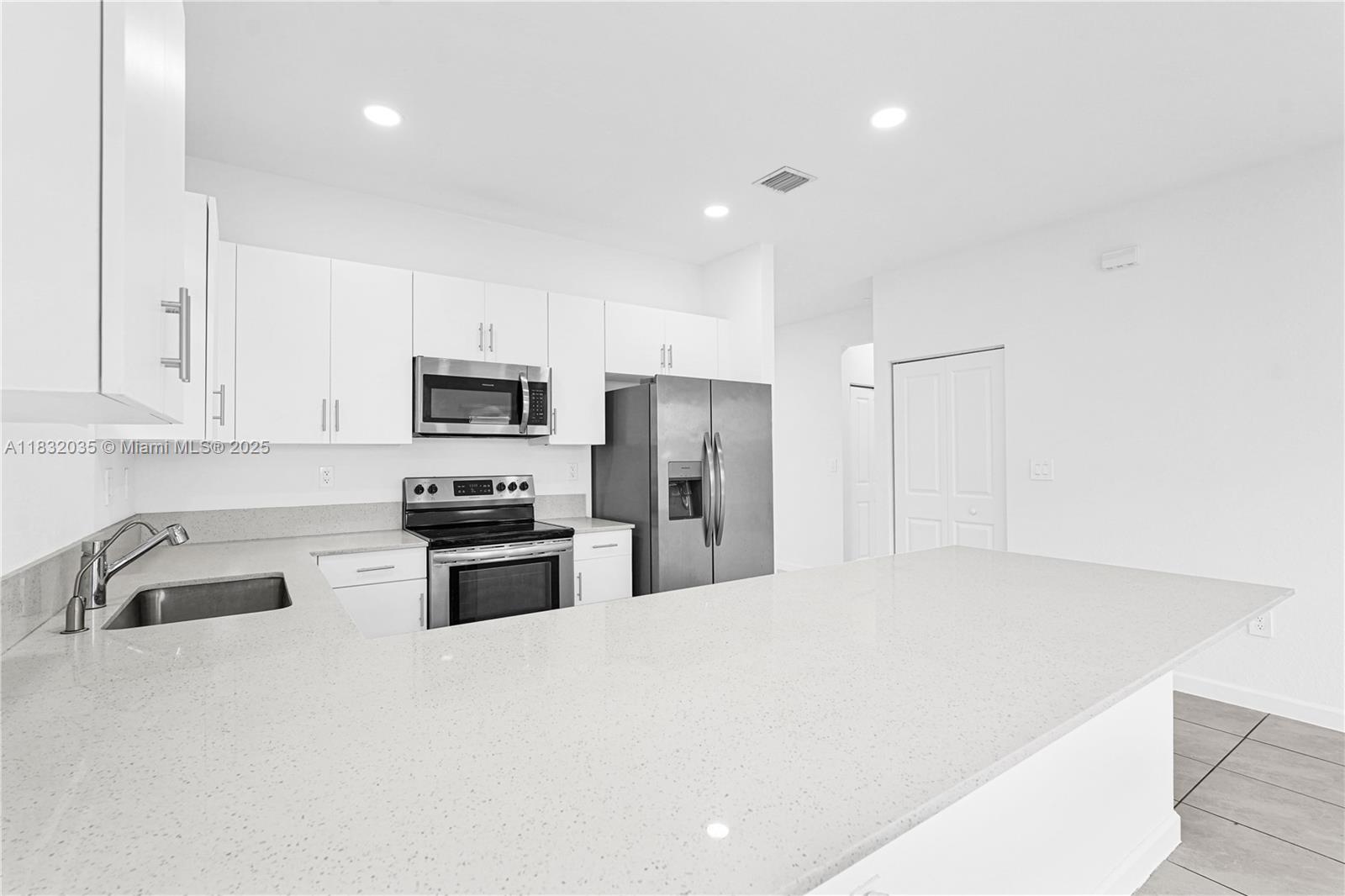 12735 Southwest 211th Street, Unit 12735 Miami, FL 33177 - Photo 33 of 45 a kitchen with granite countertop white cabinets and stainless steel appliances