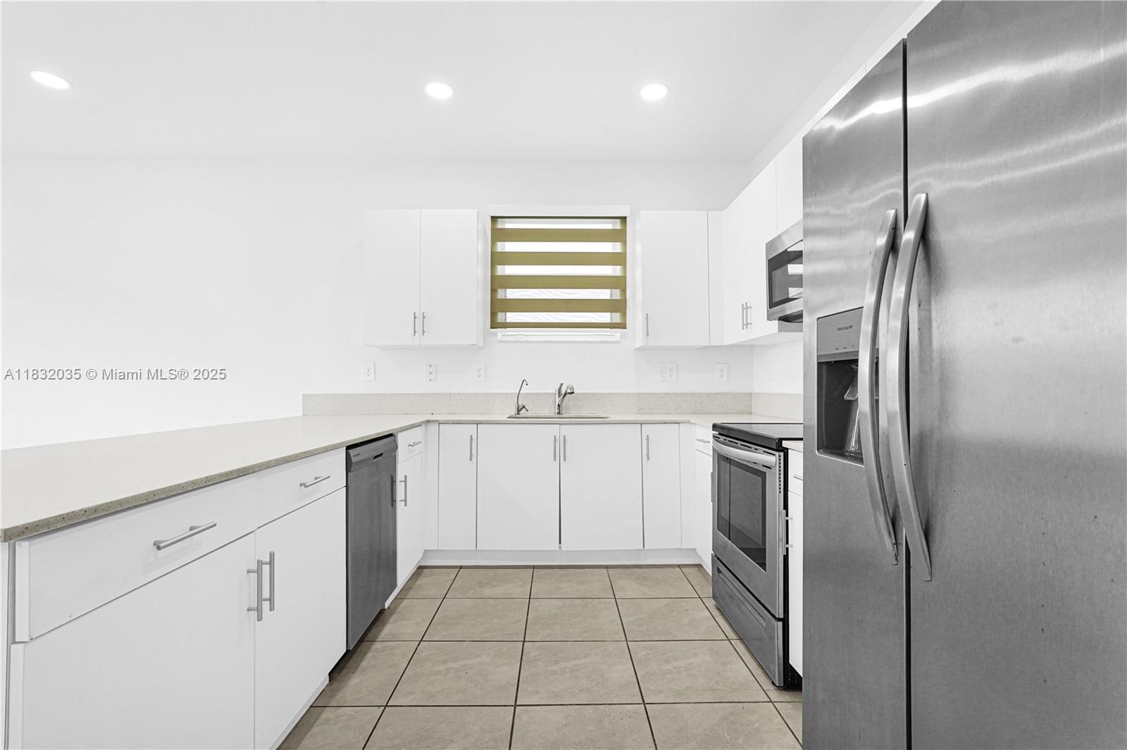 12735 Southwest 211th Street, Unit 12735 Miami, FL 33177 - Photo 45 of 45 a kitchen with white cabinets stainless steel appliances and a sink