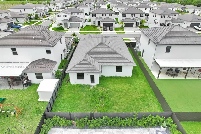 a aerial view of a house with a yard table and chairs