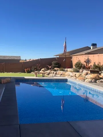 a view of swimming pool with lawn chairs