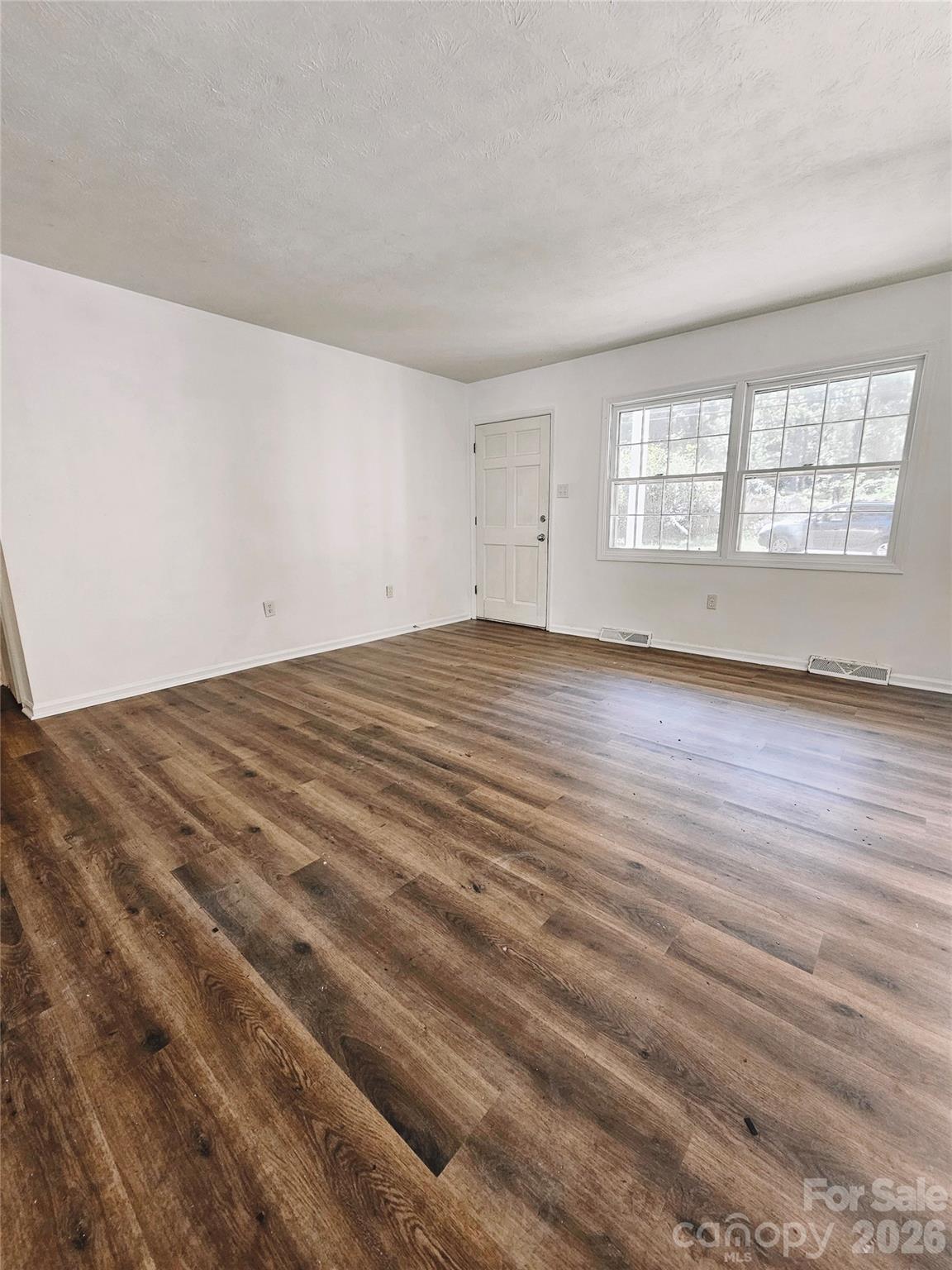 468 Beaverdam Road Asheville, NC 28804 - Photo 11 of 19 a view of an empty room with wooden floor and a window