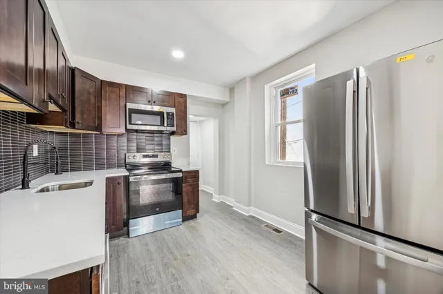 a kitchen with stainless steel appliances wooden cabinets and a refrigerator