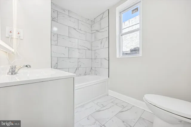 a bathroom with a sink a toilet and window