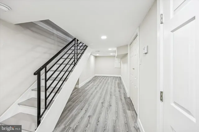 a view of a hallway with wooden floor and staircase