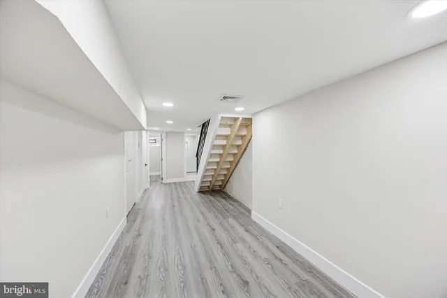 a view of an empty room with wooden floor