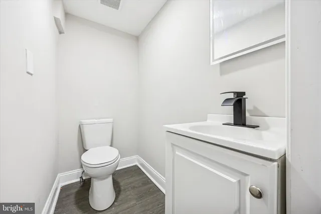 a bathroom with a sink a toilet and a mirror