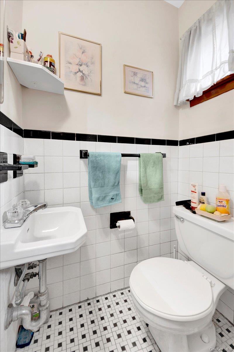 733 Rhinelander Avenue Bronx, NY 10462 - Photo 13 of 31 Half bathroom with tile patterned floors and tile walls