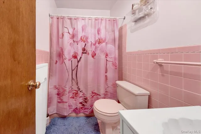 a bathroom with a toilet sink and shower curtain