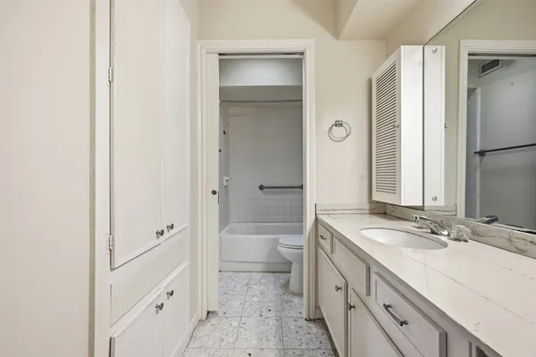 a bathroom with a double vanity sink toilet mirror and a bathtub