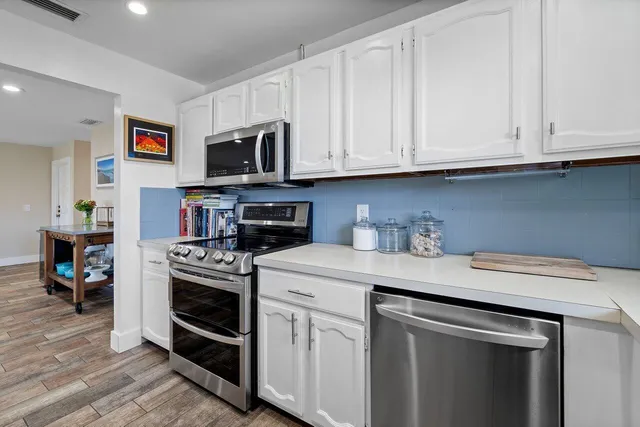 a kitchen with stainless steel appliances granite countertop a stove a microwave and a refrigerator