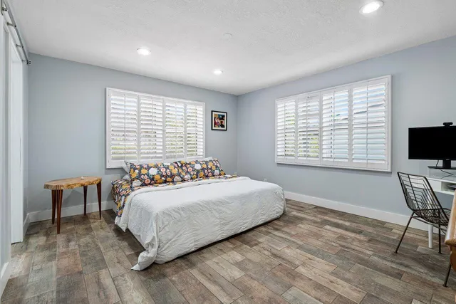 a bedroom with a bed and a flat screen tv