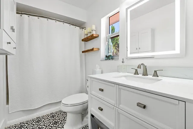 a bathroom with a granite countertop sink toilet and shower