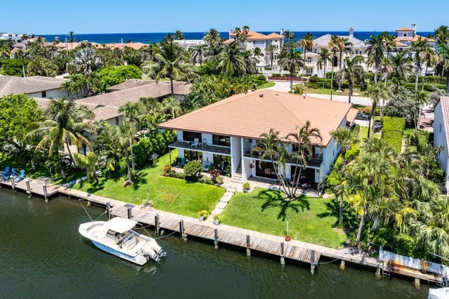an aerial view of a house with a garden and lake view
