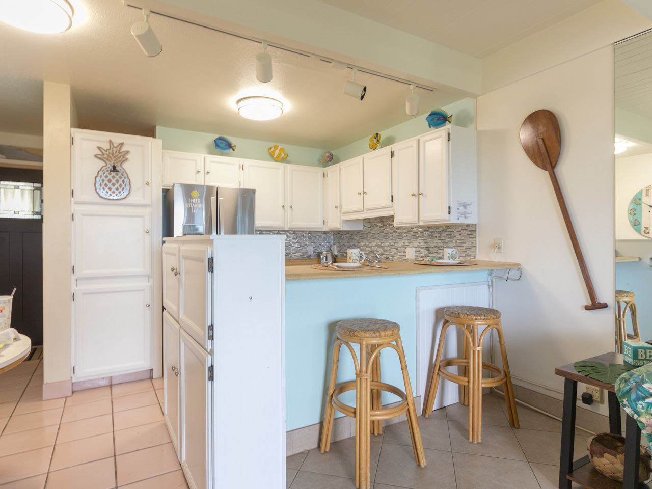 2075 South Kihei Road, Unit 113 Kihei, HI 96753 - Photo 13 of 24 a kitchen with stainless steel appliances granite countertop a table chairs and a refrigerator