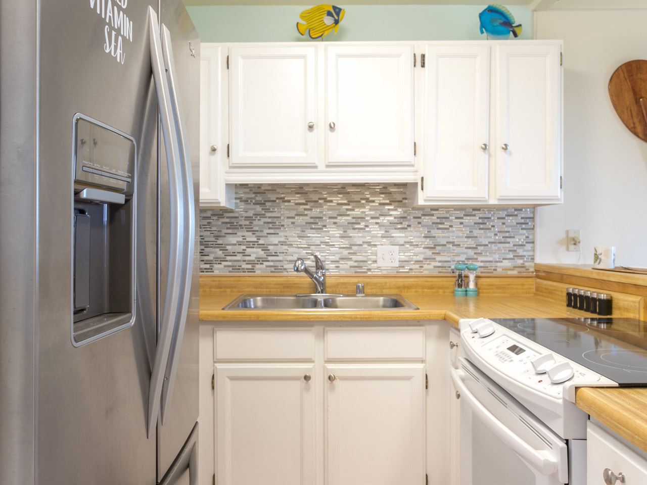 2075 South Kihei Road, Unit 113 Kihei, HI 96753 - Photo 15 of 24 a kitchen with stainless steel appliances granite countertop a sink and a refrigerator