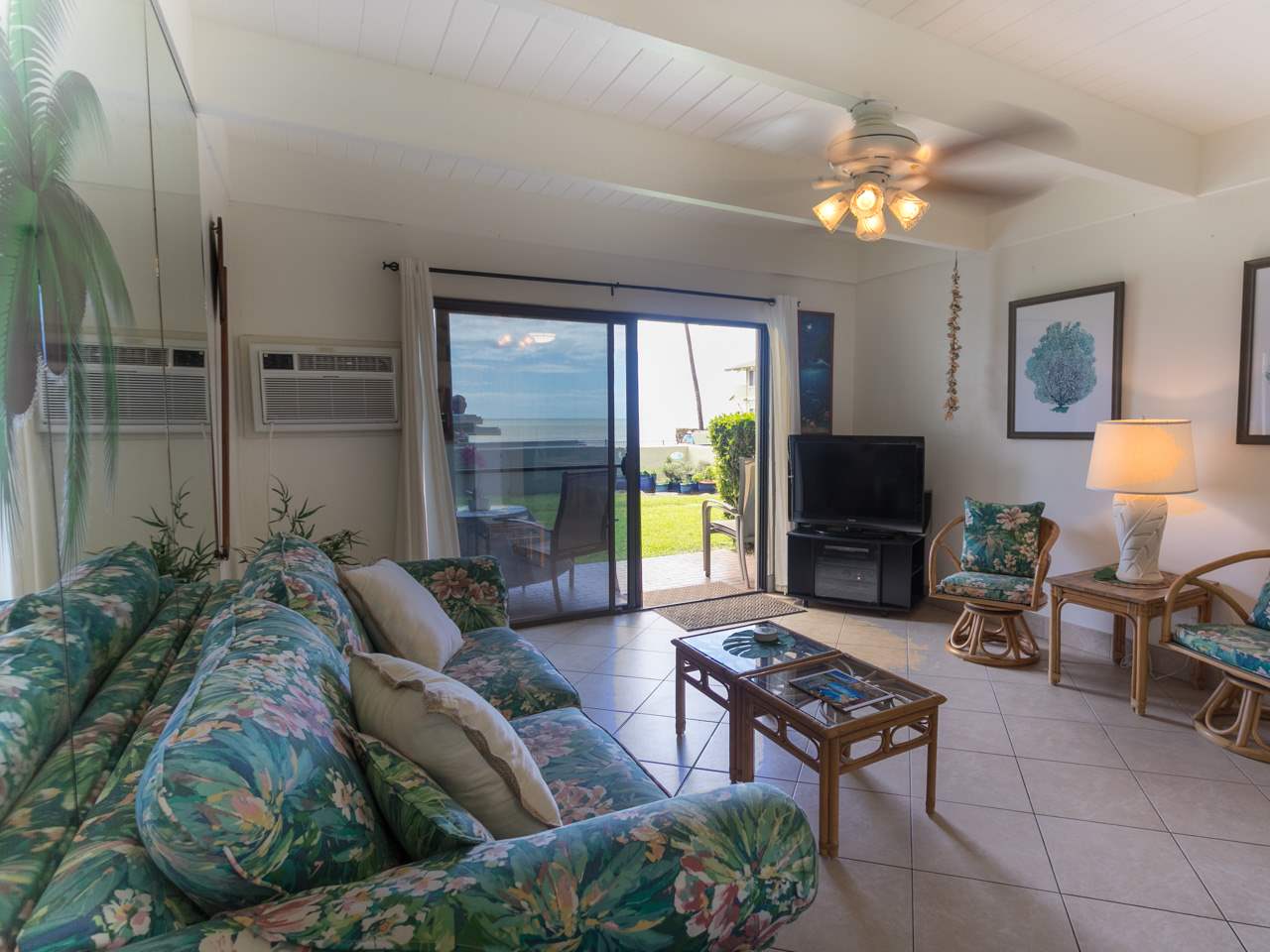 2075 South Kihei Road, Unit 113 Kihei, HI 96753 - Photo 6 of 24 a living room with furniture a chandelier and a flat screen tv