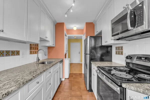 a kitchen with stainless steel appliances granite countertop a stove a sink and a refrigerator