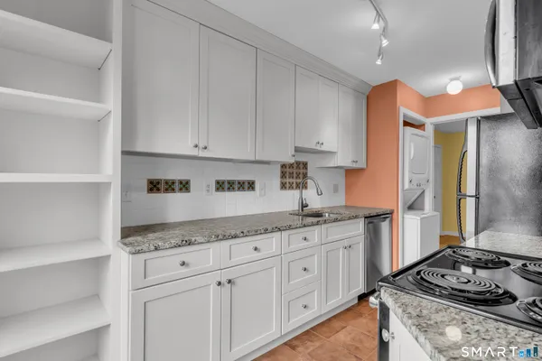 a kitchen with stainless steel appliances granite countertop a stove and a refrigerator
